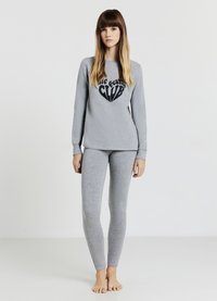 Ensemble de pyjama gris comprenant un haut à manches longues avec l'inscription « dreaming CLUB » en police noire et un legging assorti ajusté. Tissu doux, design simple.
