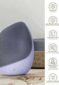 Siliconansiktsrengöringsapparat i ljuslila, rund form med texturerad yta, inkluderar knappar och har vattentålig design (IPX7).