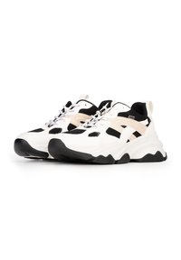 Zapatillas chunky en blanco y negro con paneles de malla, suela de goma texturizada y acentos en color crema en los laterales y la lengüeta.