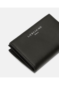 Zwarte leren portemonnee met een gladde textuur, vouwontwerp en in zilver gebosseld "LIEBESKIND BERLIN" logo. Compactus en minimalistisch.