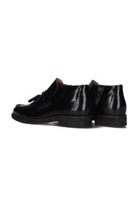 Zwarte leren schoenen met een gladde afwerking, instapontwerp met een decoratieve kwast, en een gestructureerde zool voor grip.