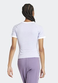 Light purple fitted t-shirt with white ribbed collar and sleeves. Soft, lightweight fabric with a smooth texture. Back view.