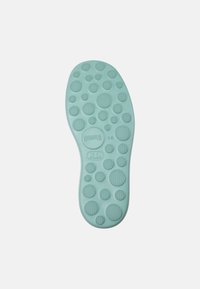 Light blue insole featuring circular patterns and textured grips. "CAMPER" logo and size 38 printed on the surface. Smooth, flexible material.