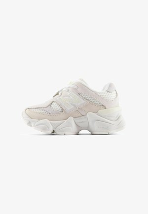 Hvid og lysebeige atletisk sneaker med mesh- og ruskind-overdel, chunky tekstureret sål og "N" logo på siden.