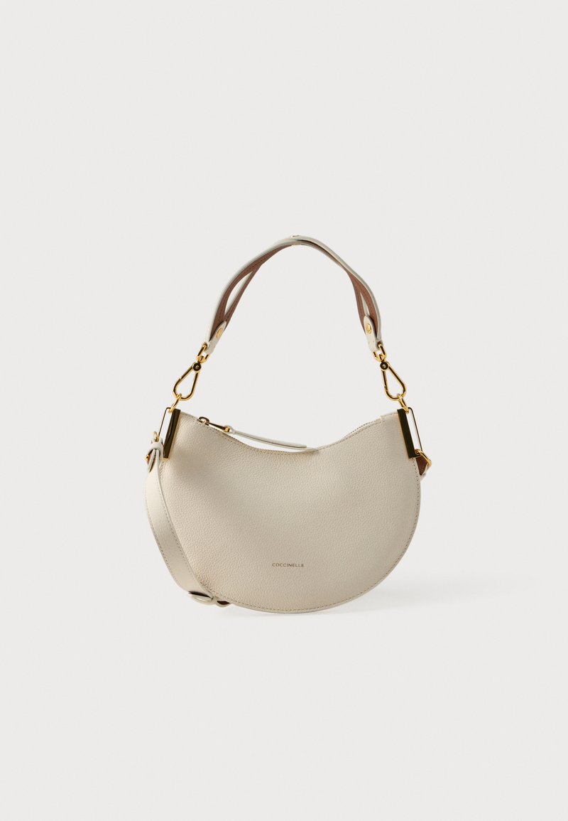 Leren schoudertas in crème, met een gebogen ontwerp, gouden hardware accenten en een gestructureerde afwerking. Voorzien van dubbele riemen voor veelzijdigheid.