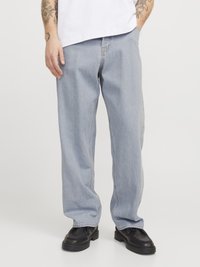 Pantalones vaqueros de denim azul claro con un corte relajado, piernas rectas y detalles de costura visibles, combinados con zapatos negros.