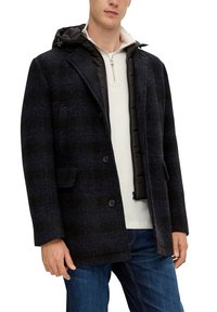 Zwart geruite jas met capuchon, voorzien van een knoopsluiting aan de voorkant, zijzakken en een gewatteerde voering. Draag het over een licht shirt.