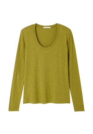 Garām piedurknēm, olīvu zaļā viegla adīta virskrekla topiņš ar noapaļotu izgriezumu, attēlots horizontālā pozīcijā uz balta fona.