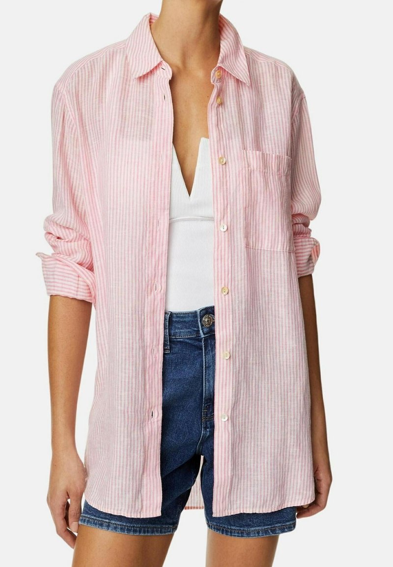 Lichtroze en wit gestreepte overhemd met knopen, gemaakt van stof, met een borstzak, lange mouwen opgerold bij de manchetten, gedragen over een wit tanktop.