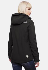 Black softshell jacket with a hood, featuring a white logo on the shoulder, smooth texture, and side seam detailing.