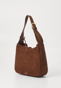 Brown suede handbag with a structured shape, adjustable leather strap, and a front pocket. Features subtle stitching and gold-tone hardware.