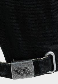 Zwarte stoffen hoed met een textuurdesign, voorzien van een zilverkleurige metalen sluiting en een gegraveerd "camel active" logo op de band.
