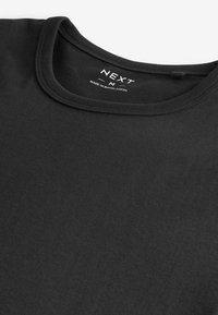 Zwarte t-shirt met een ronde hals. Gemaakt van katoen, met een soepele textuur en zonder zichtbare patronen. Het label toont "NEXT M" en het land van herkomst.