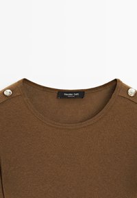 Brown knit top featuring a round neckline and metallic button accents on the shoulders; label reads "Massimo Dutti."