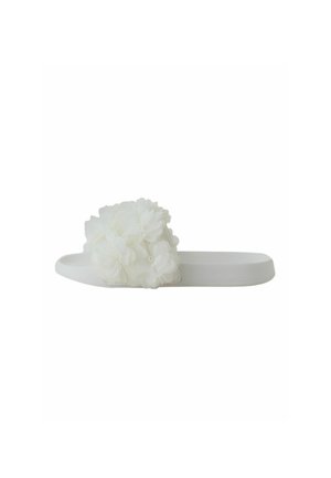 Hvid slidssandal med tyk sål og en stor dekorativ hvid stofblomst på remmen over foden.
