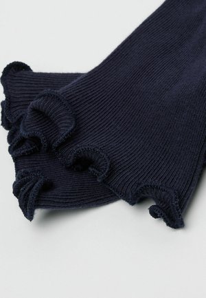 Granatowe prążkowane skarpety z falbankami przy mankietach. Wykonane z miękkiego, elastycznego materiału. Całość zdobi fakturowany wzór. Krawędzie delikatnie pofalowane.