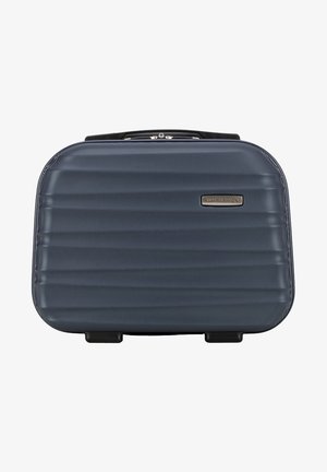 Hartschalenkoffer in Dunkelblau mit gerilltem Design, texturierter Oberfläche und einem stabilen Griff. Ausgestattet mit vier schwarzen Rädern für Mobilität.