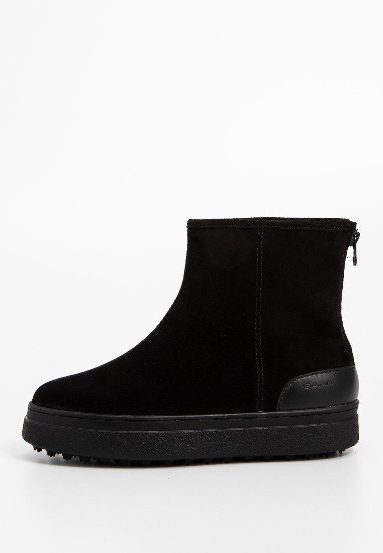 Schwarze Wildleder-Ankle-Boots mit flacher, strukturierten Sohle, Reißverschluss hinten und verstärktem Fersenpatch mit eingraviertem Markennamen.