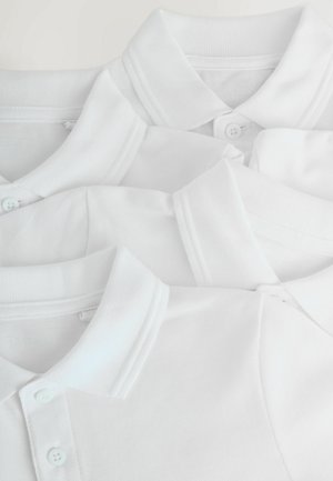 Three white polo shirts stacked closely together, highlighting their collars and buttons, with a plain background.