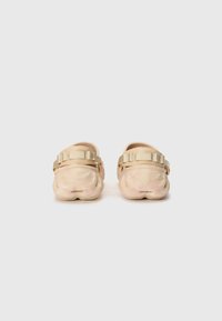 Helle rosa Clogs mit strukturierter Oberfläche und dicker Sohle. Verfügt über einen breiten, verstellbaren Riemen mit einer metallischen goldenen Schnalle.