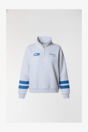 Grijs fleece sweater met een halve ritssluiting bij de kraag, blauwe strepen op de mouwen en het "CHAMPS" logo in blauw en cursieve tekstdetails.