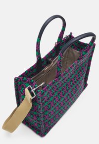 Torba tote wykonana z tkaniny w intensywnym zielono-fioletowym wzorze, z skórzanymi uchwytami, beżowym wnętrzem oraz regulowanym paskiem na ramię.
