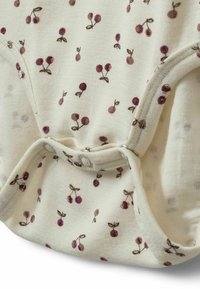 Kerman onesie värissä kerma, jossa toistuva kirsikkakuosi burgundinpunaisena ja ruskeana. Varustettu napitusalla alaosassa, mikä helpottaa pukemista.