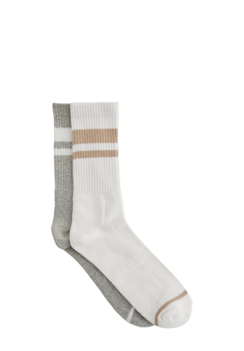 Twee paren geribde sokken: de ene is wit met beige strepen, de andere is grijs met witte strepen. Gemaakt van een zachte katoenmix, met een lengte tot halverwege de kuit.