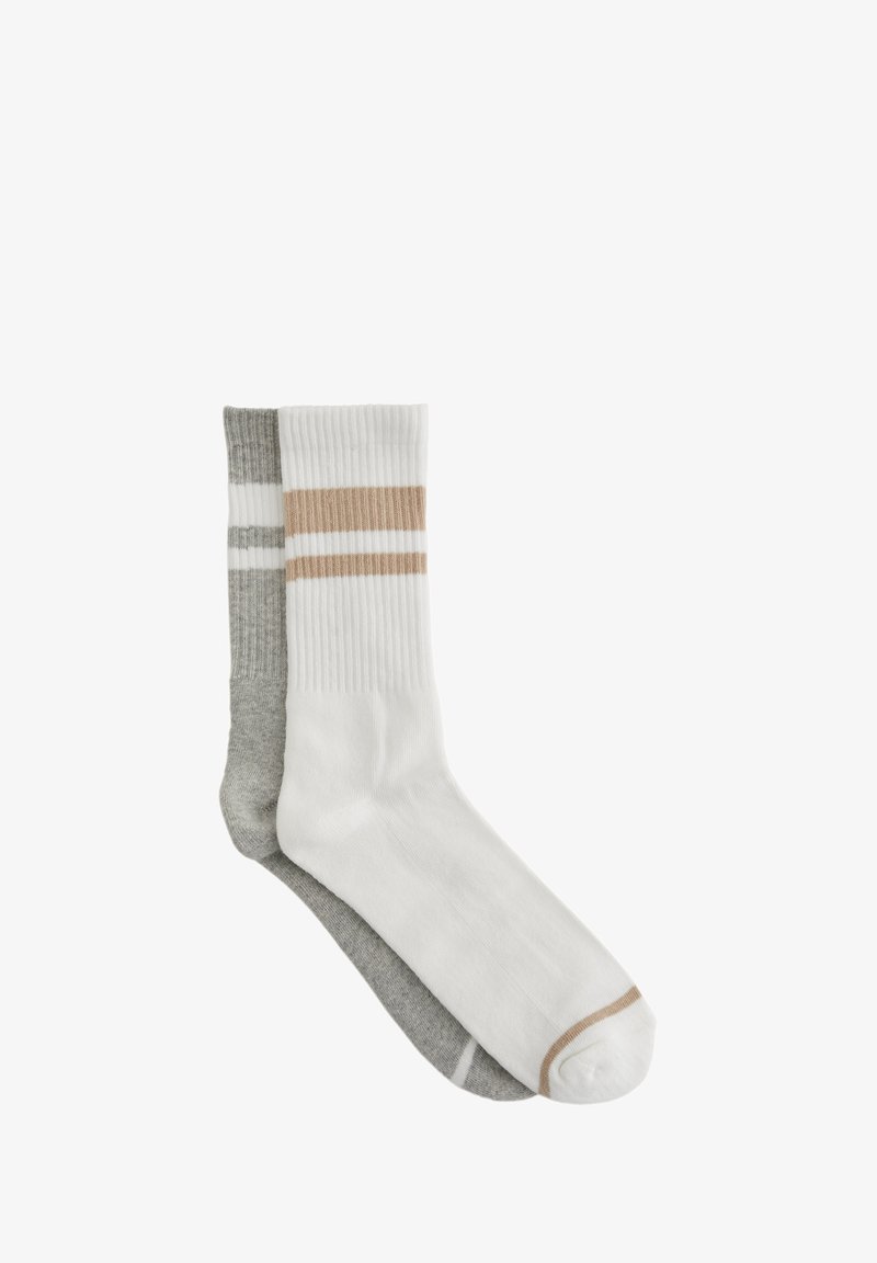 Två par ribbade strumpor: en vit med beiga ränder, den andra grå med vita ränder. Mjuk bomullsblandning, knähöga.