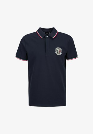 Polo shirt navy avec un col classique, orné d'accents rayés rouge, vert et blanc sur les manches et d'un logo circulaire sur la poitrine.