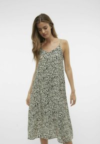 Sukienka bez rękawów w czarno-beżowym abstrakcyjnym wzorze. Krój A-liniowy z luźnym fasonem i ramiączkami spaghetti. Lekką tkanina.