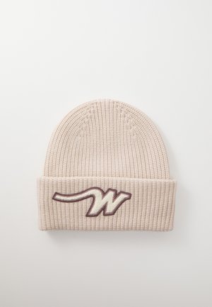 Beige strikket lue med brett, med en mørkebrun brodert logo som ligner et stilisert bokstav "W." Teksturert ribbestrikket design.
