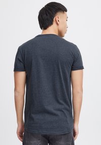 Kulkul sort kortærmet t-shirt lavet af blødt bomuld. Har rund halsudskæring og en afslappet pasform. Bagview viser rene linjer og enkelhed.