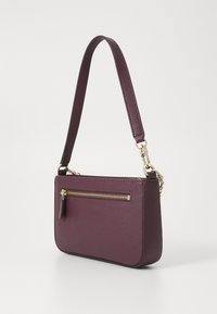 Sac bandoulière bordeaux avec surface texturée, accents dorés sur la fermeture éclair et bandoulière détachable. Il dispose d'une poche zip à l'avant pour un rangement supplémentaire.