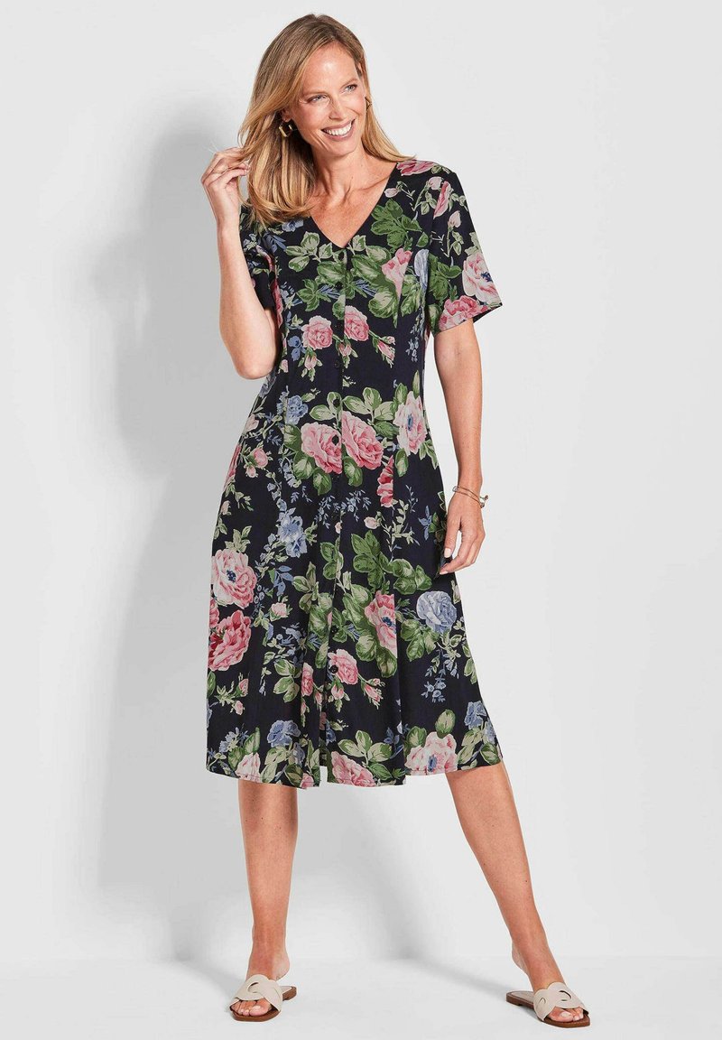 Robe noire à fleurs avec des manches courtes, un décolleté en V, et des motifs colorés de roses et de feuilles ; longueur genoux avec une coupe fluide.