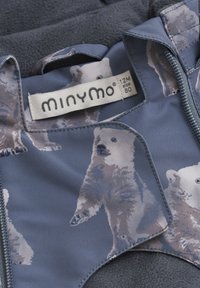 Blå stof med isbjørnemønster, med lynlåslukning. Blødt fleeceindvendigt, label viser mærket "minymo," størrelse 80, 12 måneder.