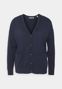 Mörkblå cardigan med v-ringning, framknäppning, två fickor och stickad textur. Har subtil perforerad detaljering på axlarna.