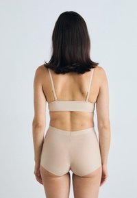 Bralette beige senza cuciture con spalline regolabili e slip a vita alta coordinati. Tessuto liscio con una consistenza morbida, design minimalista.
