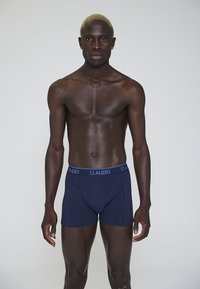Boxer briefs in cotone blu navy con un morbido elastico con testo "CLAUDIO". Il tessuto ha una texture liscia, progettata per il comfort.