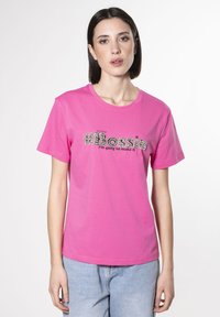 Camiseta de algod�ón rosa con el texto "#Boss" en bordado texturizado y "Voy a lograrlo" abajo. Corte casual, mangas cortas, escote redondeado.