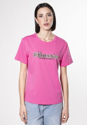 T-shirt en coton rose avec le texte "#Boss" en broderie texturée et "Je vais y arriver" en dessous. Coupe décontractée, manches courtes, col rond.