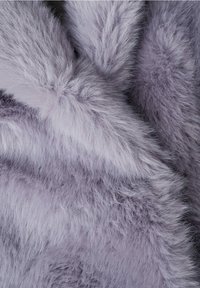 Tessuto di pelliccia morbida e soffice di colore lavanda, con trame dense e soffici e pieghe naturali che creano un aspetto accogliente.