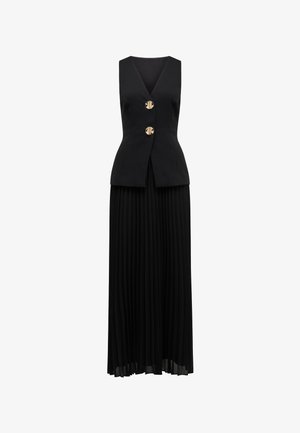 Black dress featuring a sleeveless, deep V-neck bodice with a fitted waist, adorned with two gold buttons, and a flowing pleated skirt.