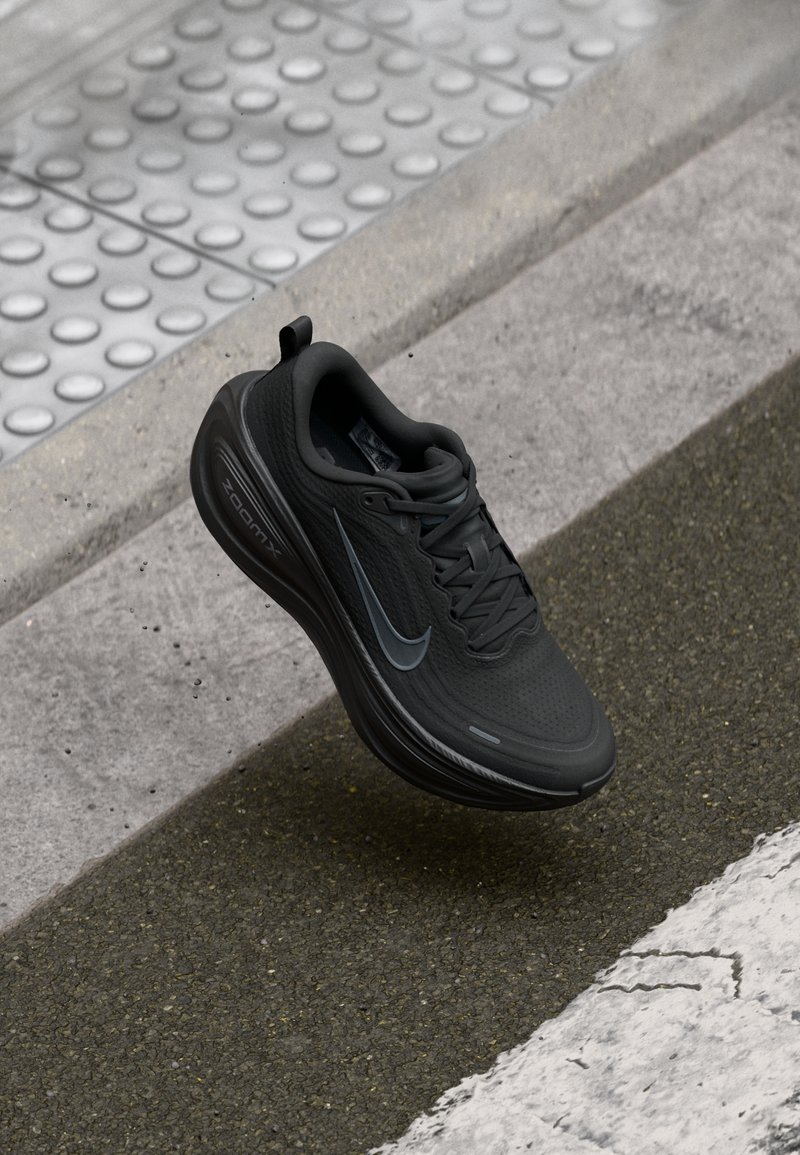 Chaussure de sport noire avec tige en mesh, bout arrondi et col rembourré. Présente un logo swoosh gris et la marque "ZOOMX" sur la semelle intermédiaire.