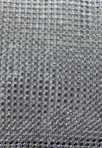 Rhinestone verkkoaine, jossa hopeiset pyöreät kivet on aseteltu riveihin harmaata taustaa vasten, luoden heijastavan ja tekstuuripintaisen pinnan.