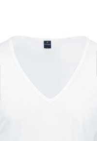 Witte katoenen t-shirt met een diepe V-hals. De stof lijkt glad met een zachte textuur en behoudt een eenvoudige, minimalistische stijl.