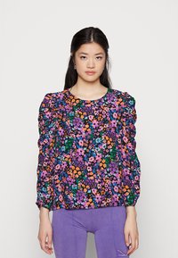 Blusa floral com um padrão colorido de flores roxas, laranjas e azuis sobre um fundo preto; mangas bufantes e decote redondo.