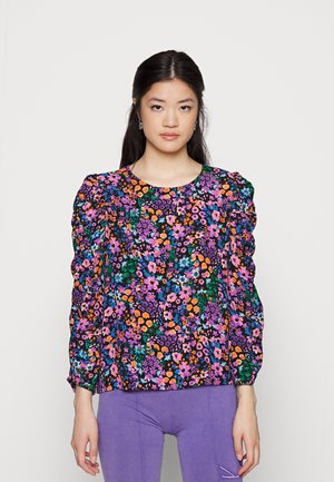 Blusa floral com um padrão colorido de flores roxas, laranjas e azuis sobre um fundo preto; mangas bufantes e decote redondo.