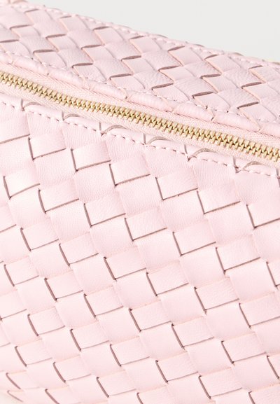 Ροζ πλεκτή δερμάτινη θήκη με χρυστό φερμουάρ που δείχνει λεπτομερώς την υφή και το ράψιμο στην επιφάνεια.