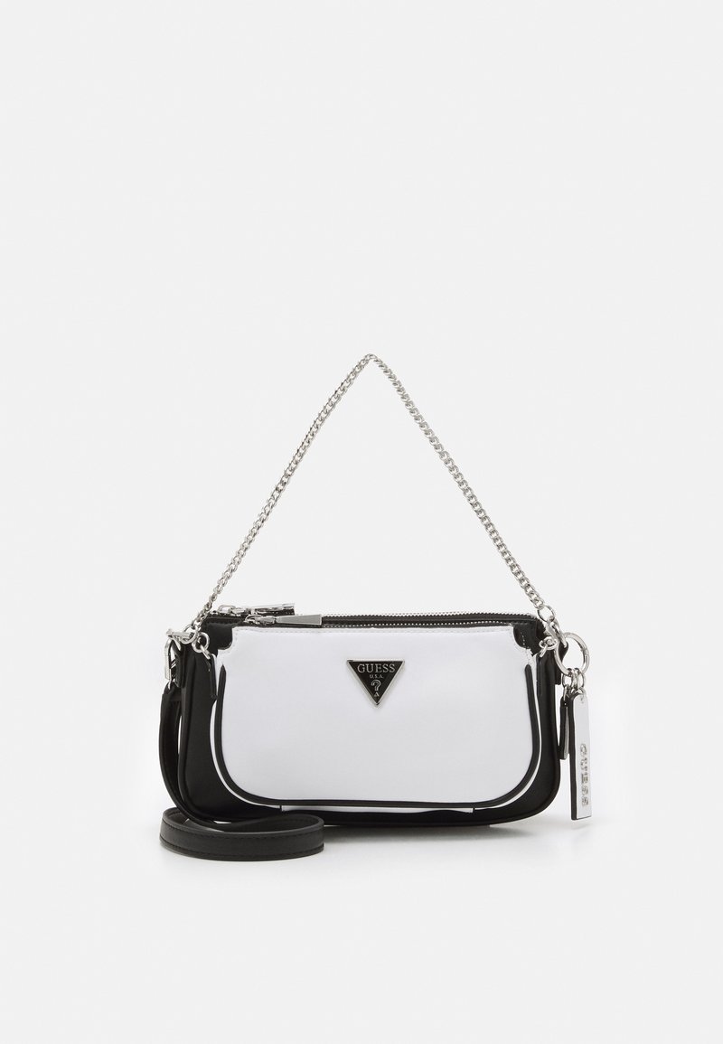 Sorte og hvide håndtaske med en blank finish, der har en kædetraspe, lynlåslukning og et trekantet logoemblem på forsiden.